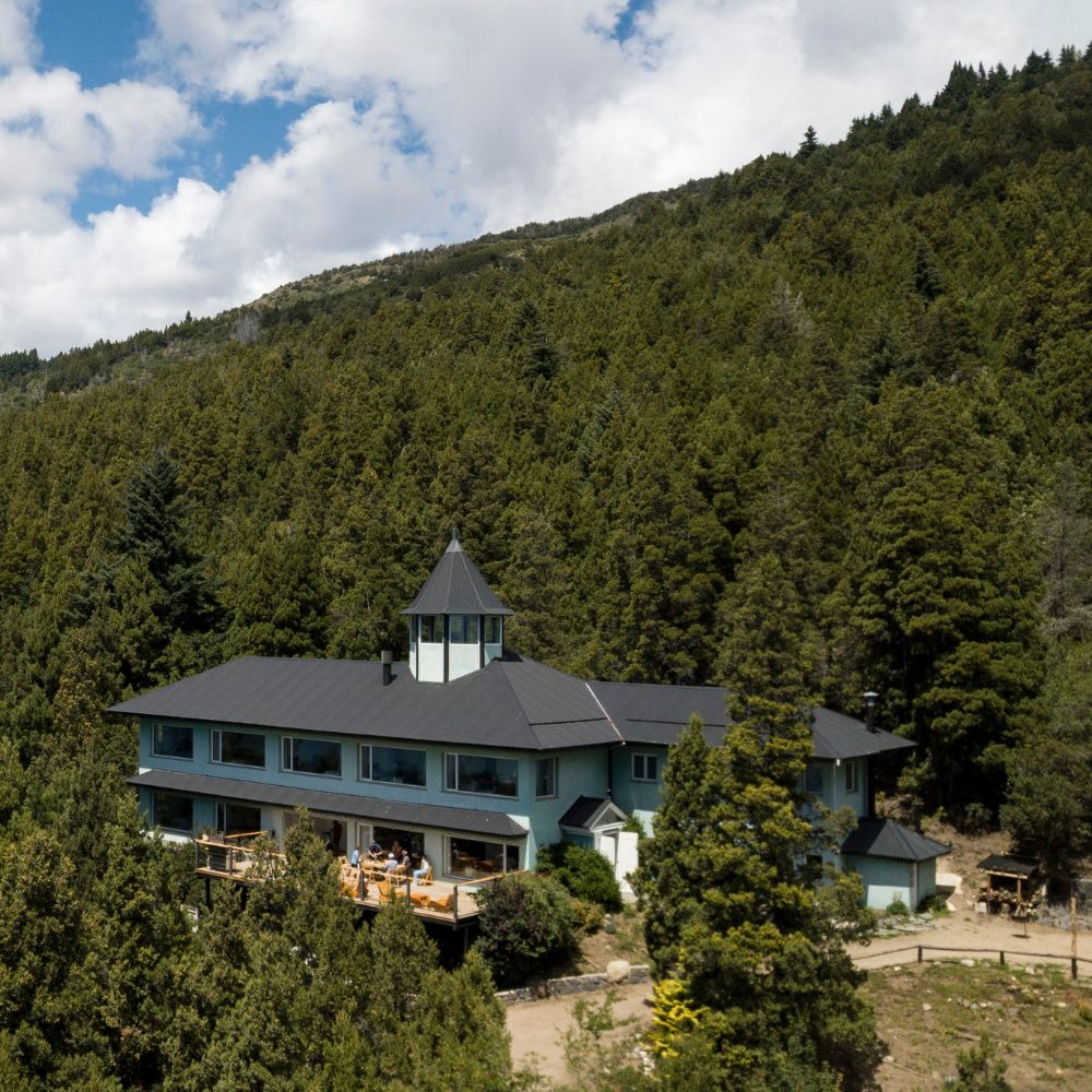 La casa del Camp, en medio del bosque, con el cerro detr&aacute;s